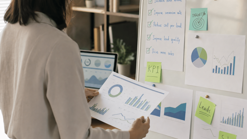 marketing performance review checklist — consultant reviewing analytics reports and KPI checklist on a whiteboard
