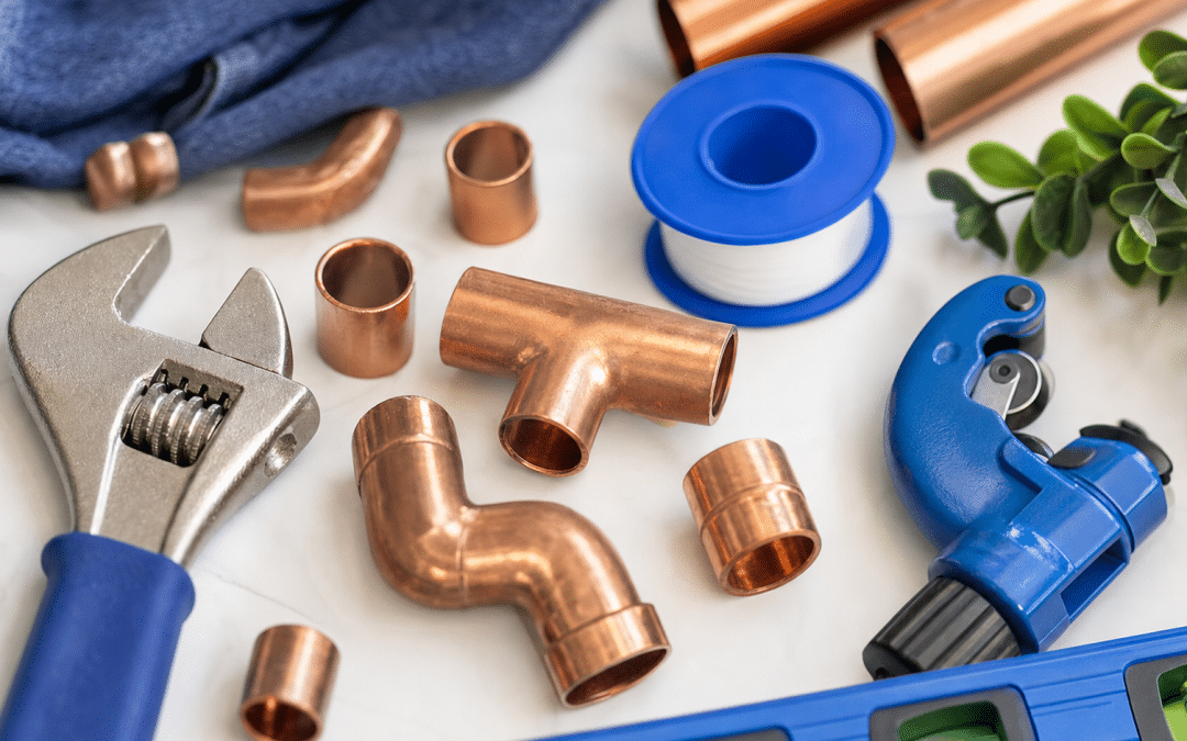 website design for plumbers — plumbing tools and fittings flat-lay on white surface